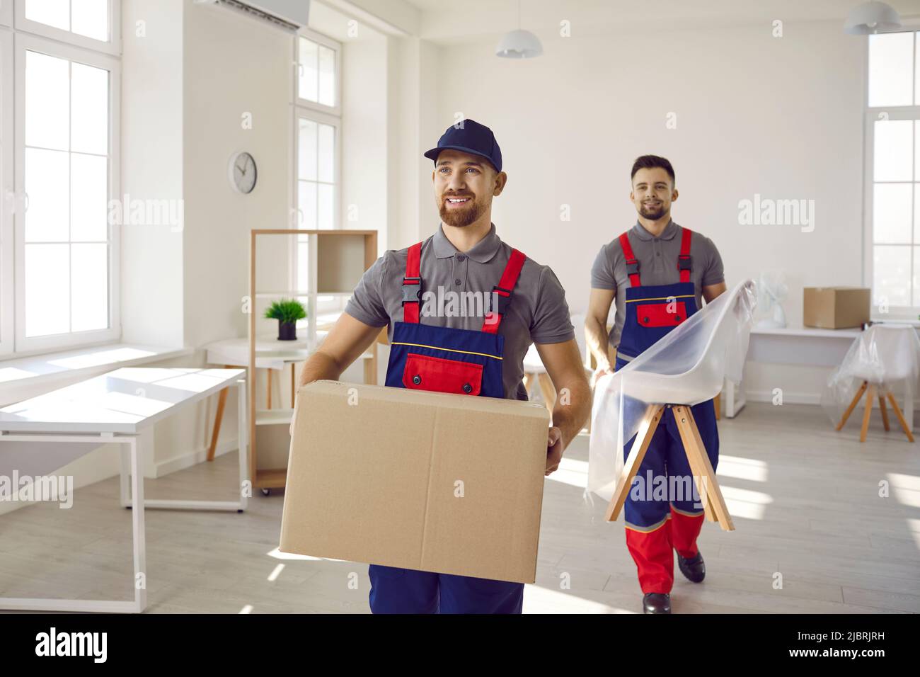 Deux jeunes travailleurs heureux du service de livraison de camions transportant des meubles et des boîtes Banque D'Images