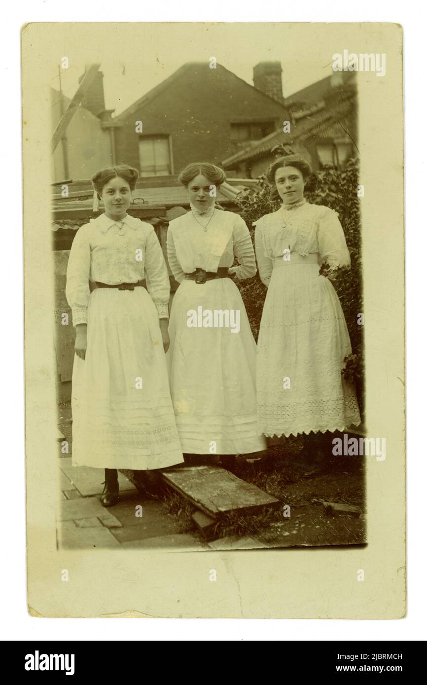 Carte postale originale du portrait de l'époque Titanic de 3 adolescentes attrayantes, l'une appelée Rose, se posant ensemble à l'extérieur dans un jardin, portant des robes d'été blanches, publiée le 8 août 1912, Bristol, Royaume-Uni Banque D'Images