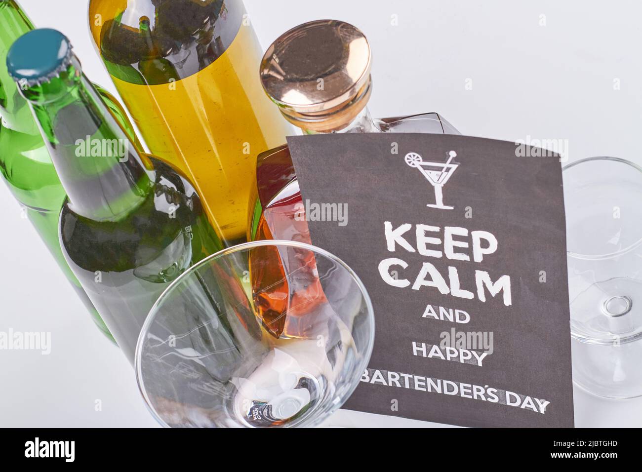 Gardez les barmans calmes et heureux jour. Beaucoup de bouteilles d'alcool sur fond blanc. Vue de dessus boissons alcoolisées. Banque D'Images