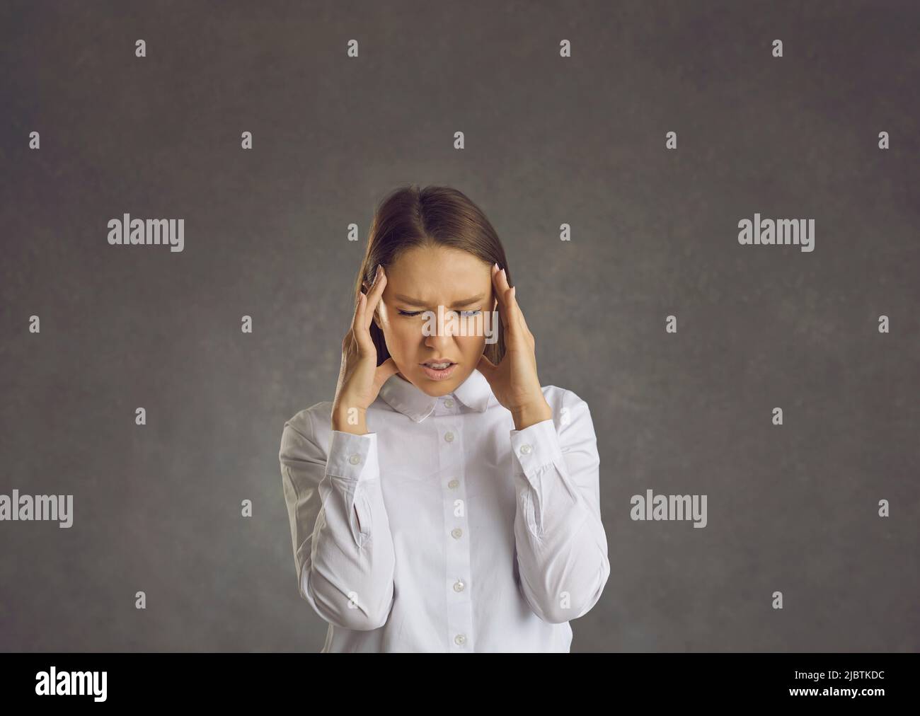 Femme stressée ayant des maux de tête frottant des temples avec la main studio portrait shot Banque D'Images