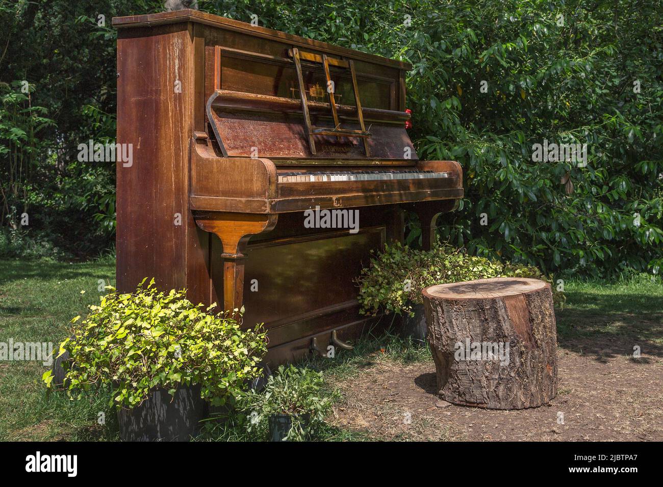 Un piano délabré debout seul dans un champ. Non désiré, solitude, abandon ou vacances, changement de concept de décor. Banque D'Images