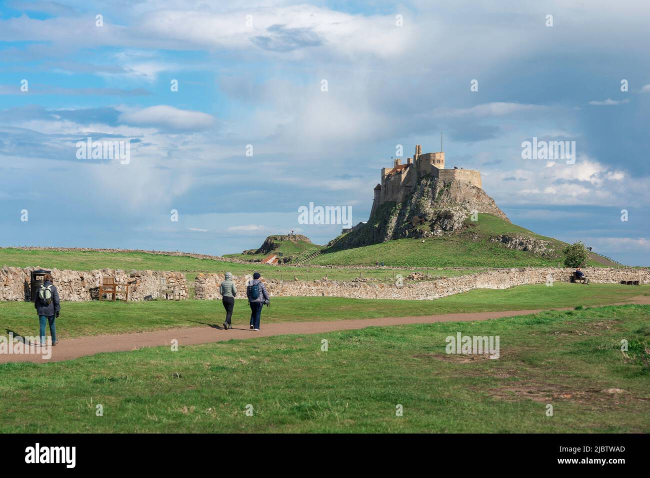 Île Sainte Lindisfarne, vue en été des personnes marchant vers le château du 16th siècle situé sur l'île Sainte (Lindisfarne), Angleterre, Royaume-Uni Banque D'Images