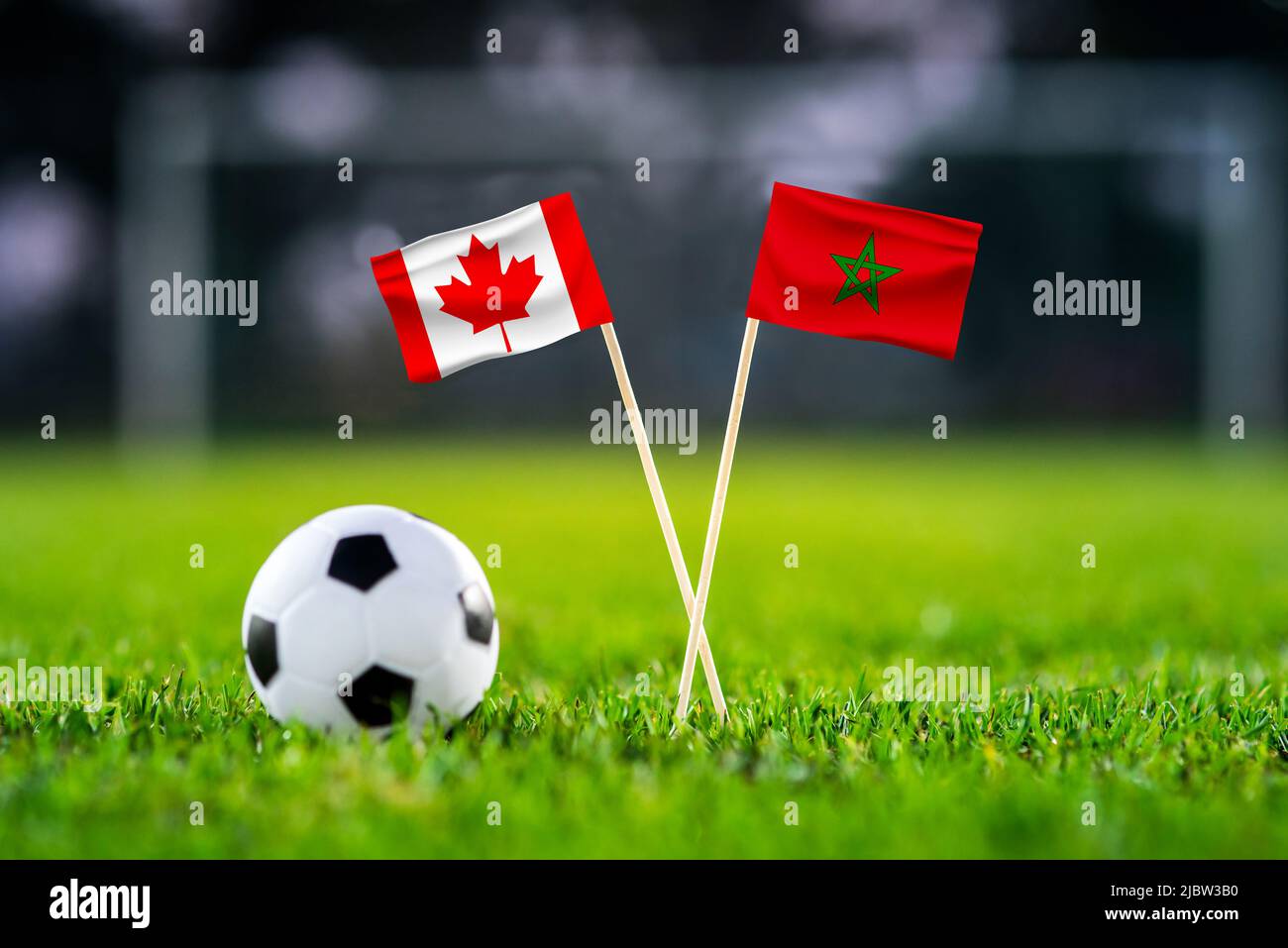 Canada contre Maroc, Al Thumama, papier peint du match de football, drapeaux nationaux faits à la main et ballon de football sur l'herbe verte. Stade de football en arrière-plan. BLAC Banque D'Images