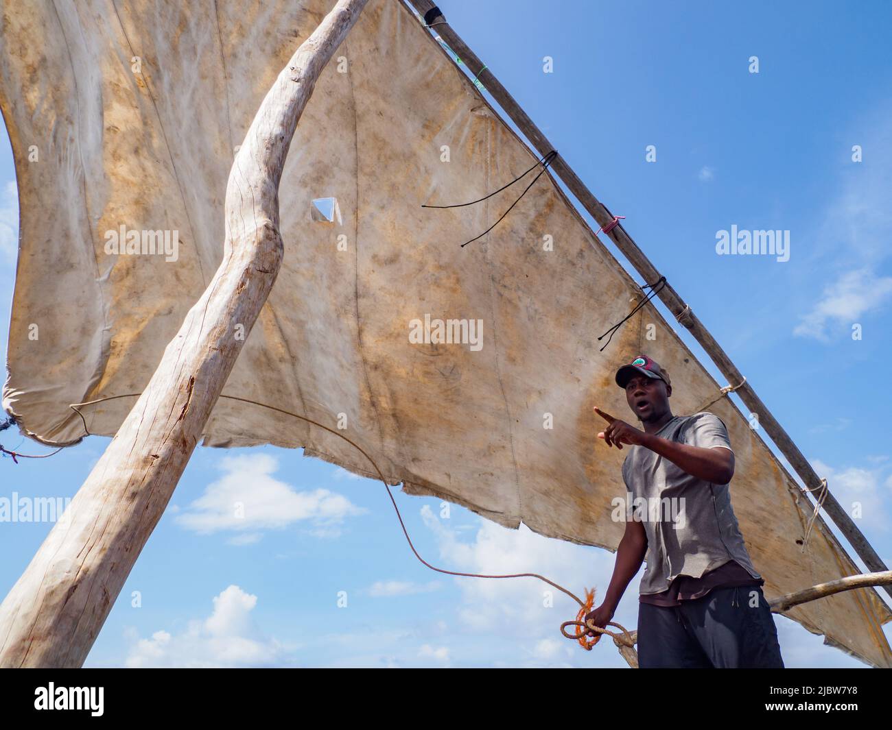 Zanzibar, Tanzanie - janvier 2021 : jeunes pêcheurs africains qui mettent la voile sur un bateau à voile traditionnel de dhow Banque D'Images