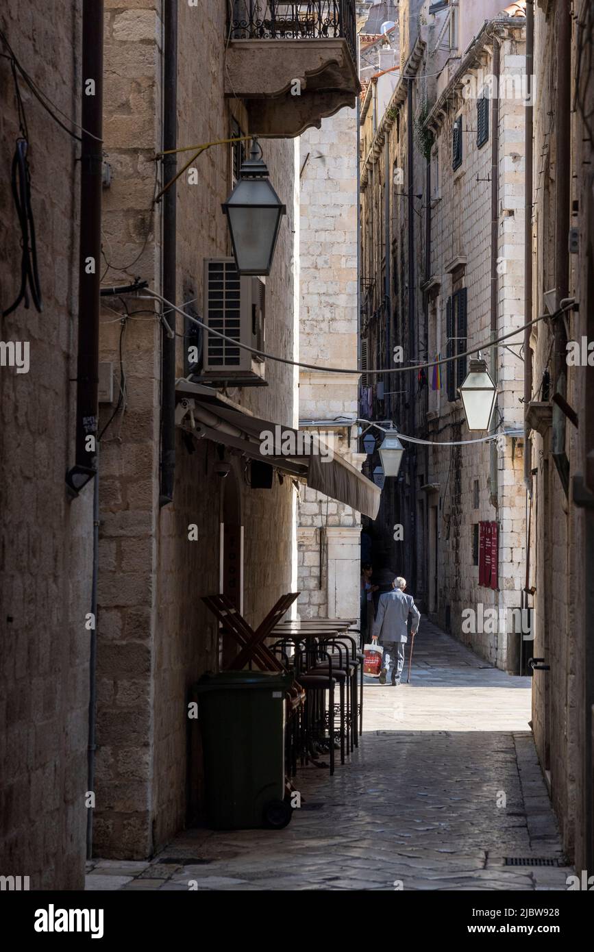 Homme âgé avec canne à pied dans la rue étroite de la vieille ville, Dubrovnik, Croatie Banque D'Images