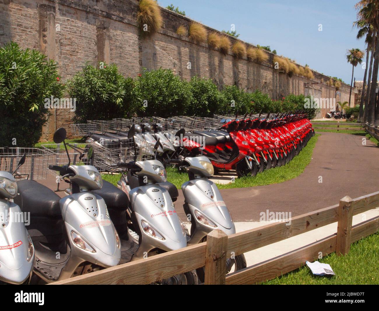 Des scooters sont alignés sur le parking de l'arsenal de la Royal Navy sur l'île des Bermudes. Les scooters attendent la location par les touristes pour des excursions autour de l'île. Banque D'Images