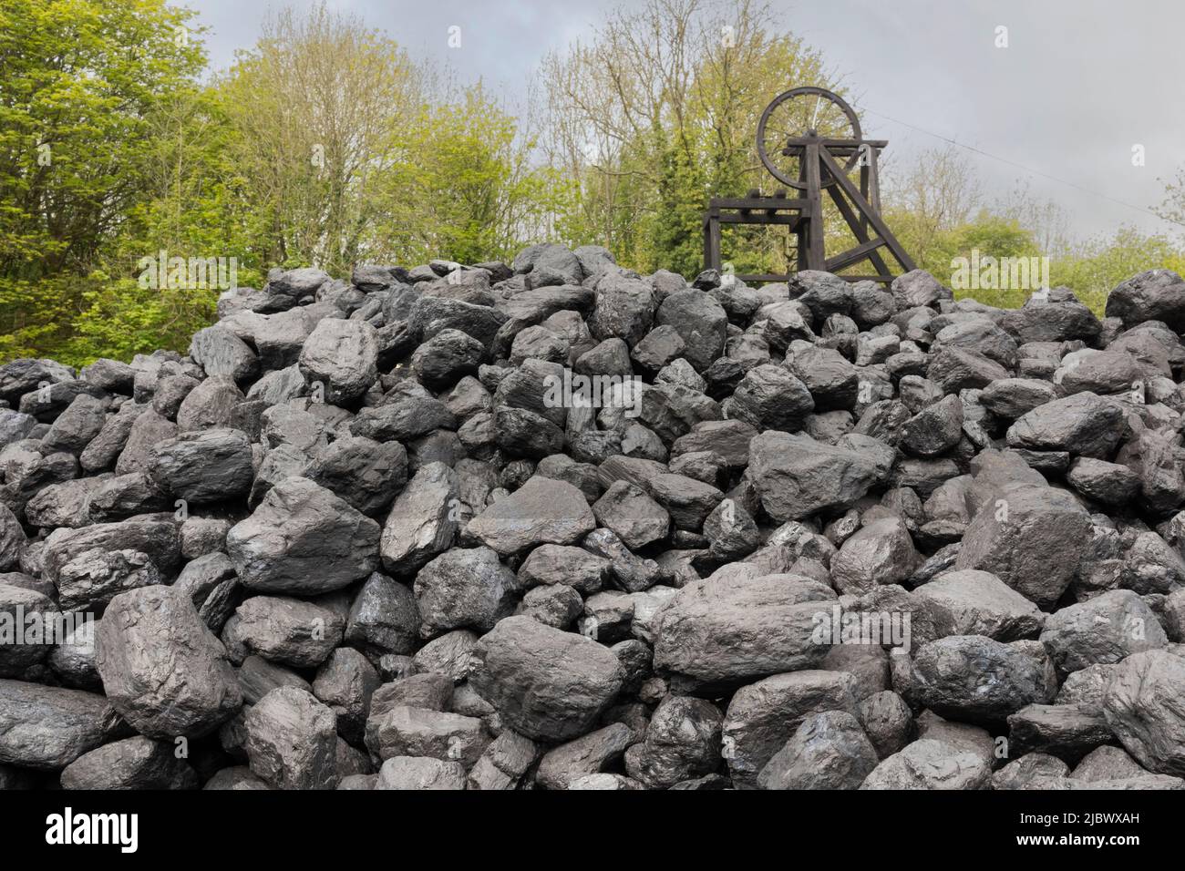 pile de charbon avec ancienne roue minière en arrière-plan Banque D'Images