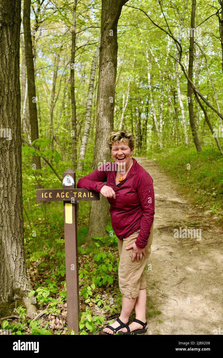 Femme randonneur debout et penchée sur le sentier de marquage de chemin dans la forêt pour le sentier panoramique national de l'âge de glace, lac Elkhart, Wisconsin, États-Unis Banque D'Images