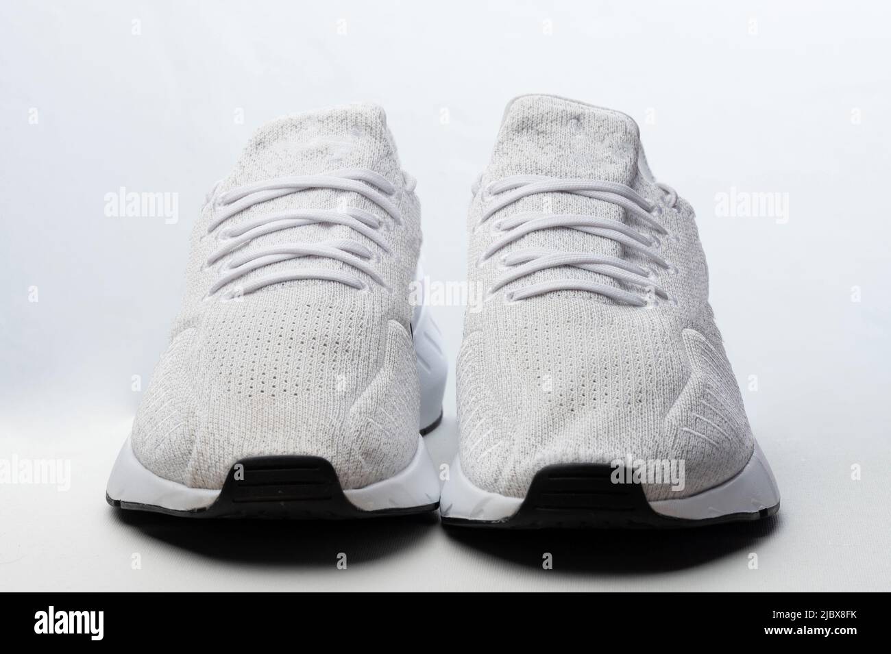 Vue avant des chaussures de sport blanches isolées sur fond de studio Banque D'Images Vue avant des chaussures de sport blanches isolées sur fond de studio Banque D'Images