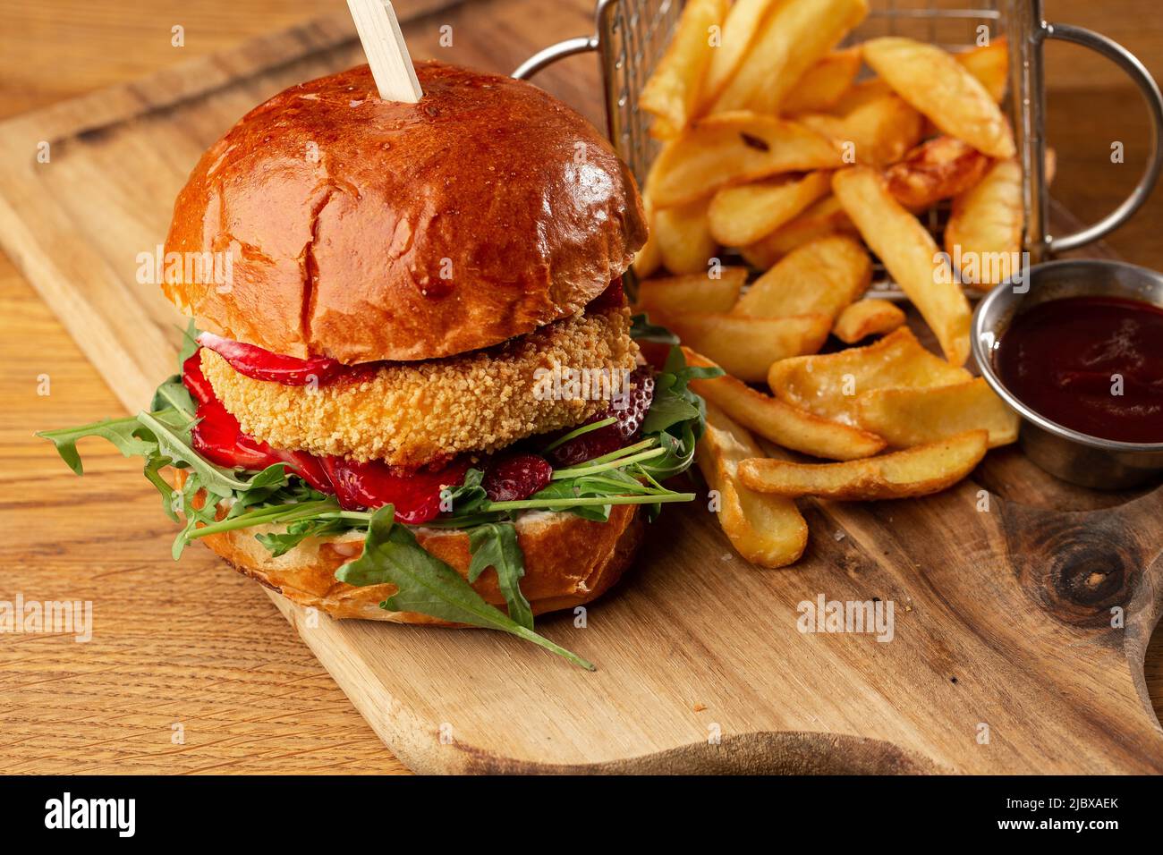 Gros cheeseburger avec frites. Hamburger avec patty de bœuf oignon, tomate, laitue cornichons, cheddar fondu, moutardes, confiture de tomates, mayonnaise. Banque D'Images