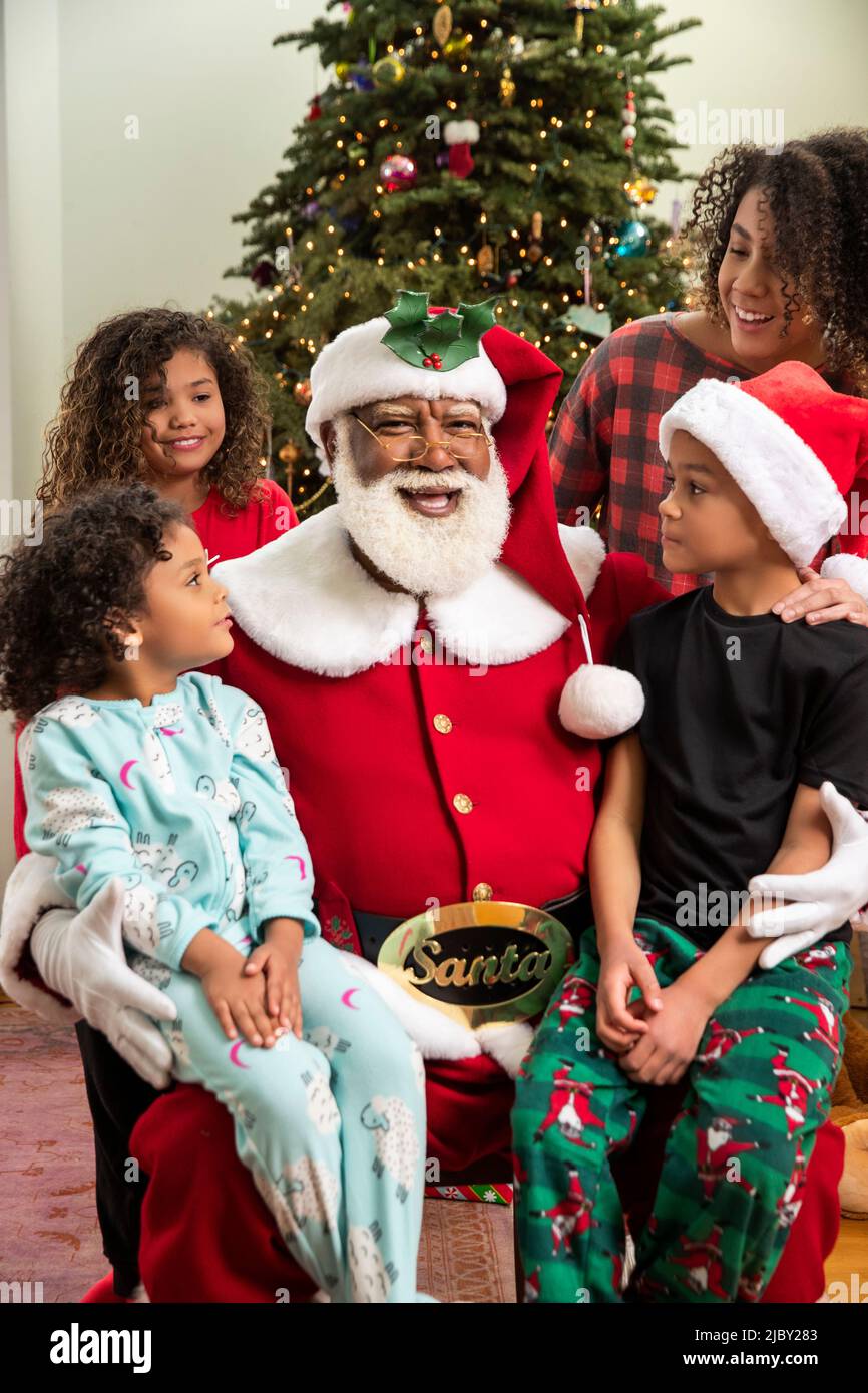 Une famille afro-américaine heureuse s'est rassemblée autour du Père Noël. Série Père Noël noir. Banque D'Images