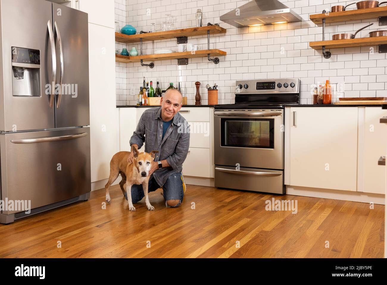 Portrait à angle bas de l'homme et de son animal de compagnie ensemble dans la cuisine. Banque D'Images