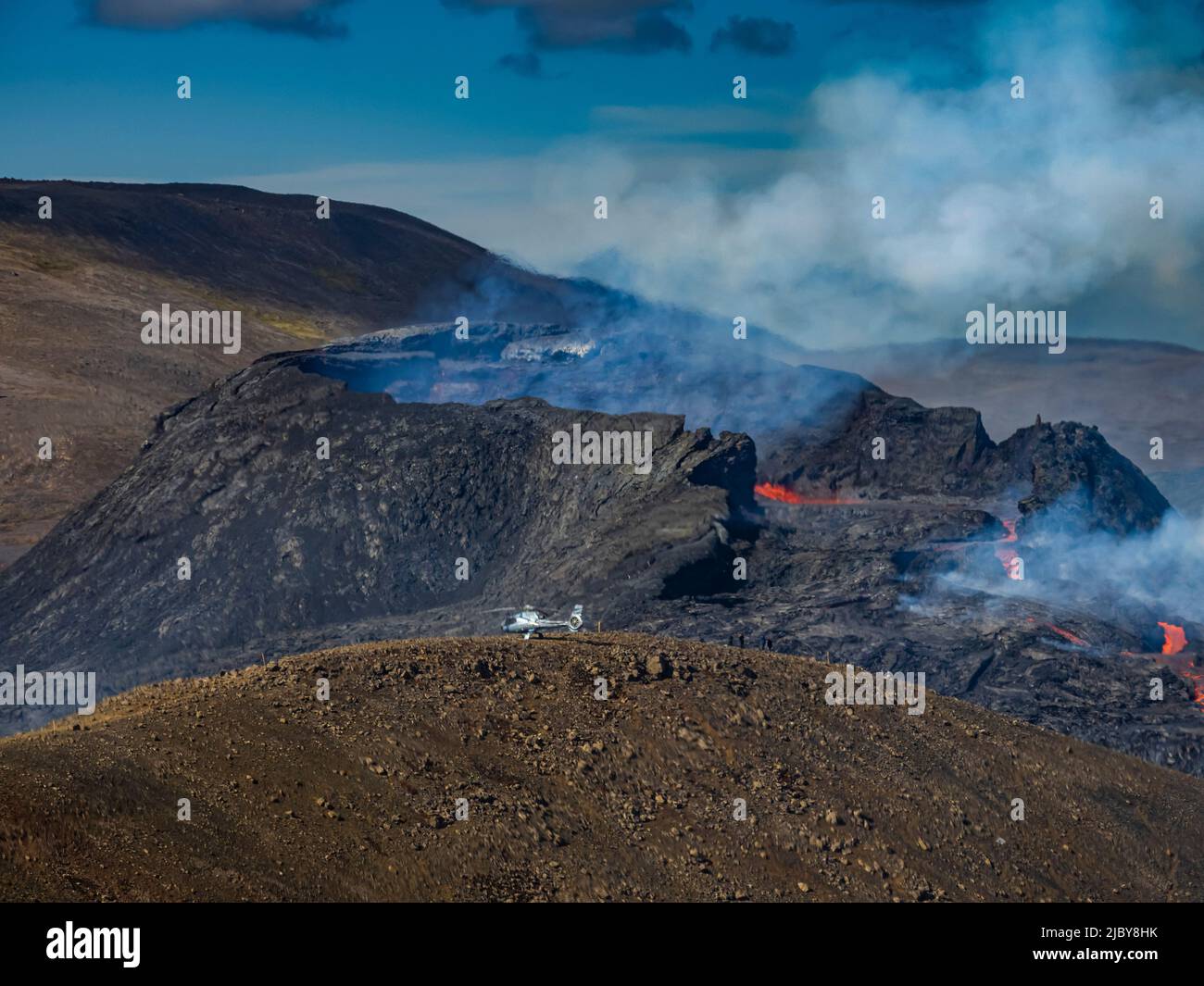 Photo aérienne, des hélicoptères atterrissent sur la colline d'observation près du cratère de Fagradalsfjall, éruption volcanique à Geldingadalir, Islande Banque D'Images