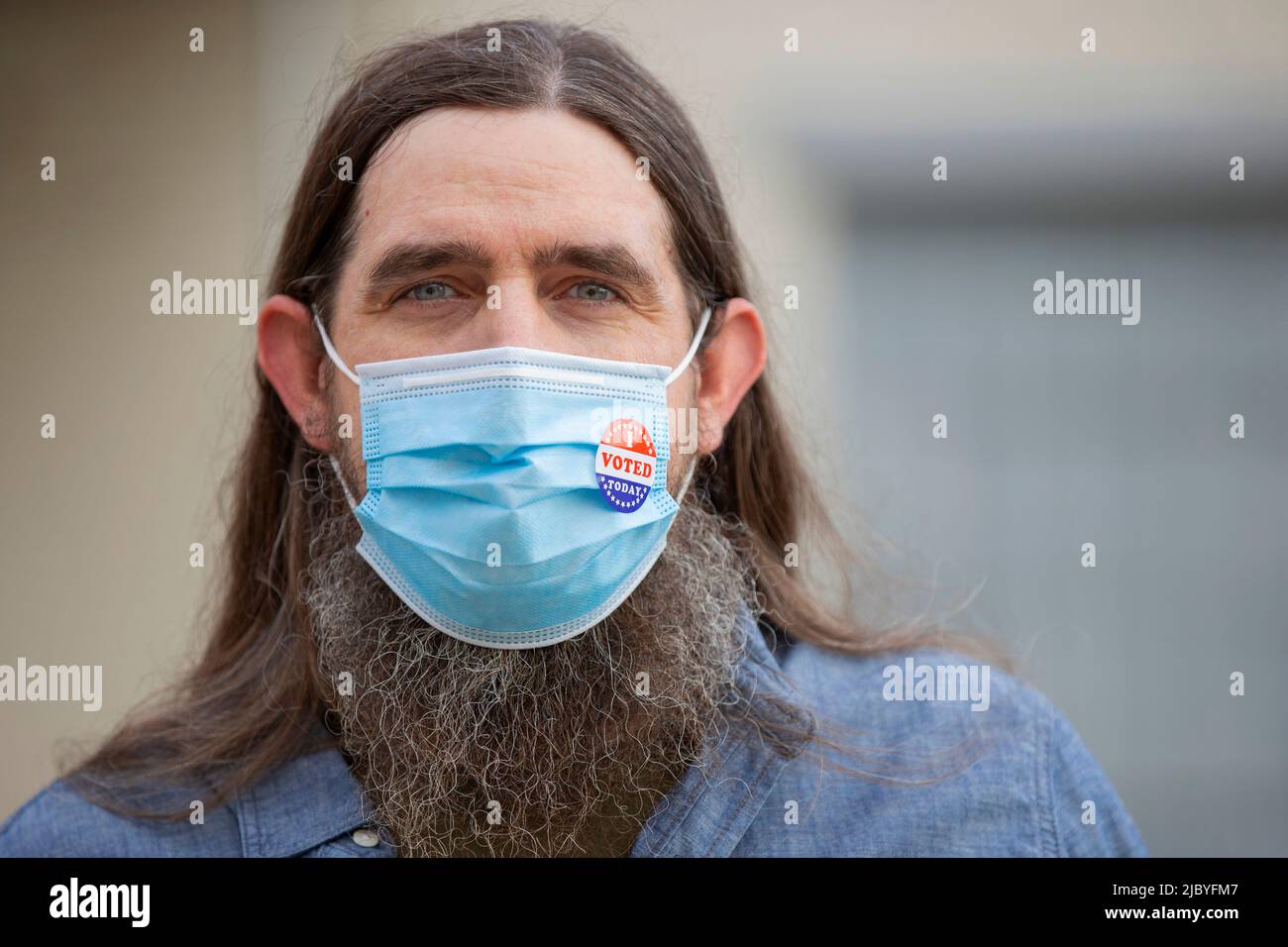 Portrait d'un homme caucasien avec de longs cheveux et une barbe complète portant un masque et un autocollant J'ai voté aujourd'hui sur le masque Banque D'Images