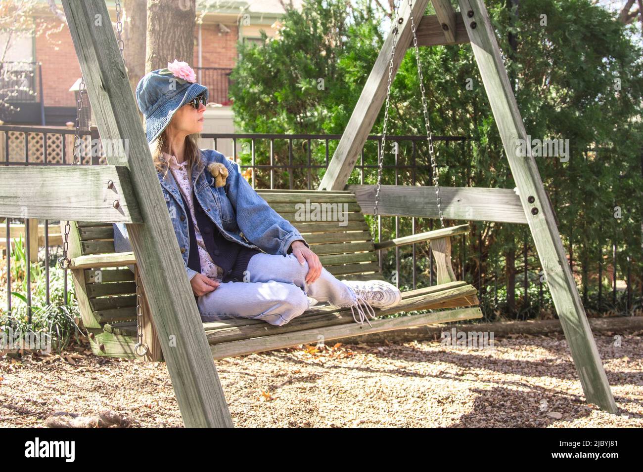 Femme assise sur un banc de swing Banque D'Images