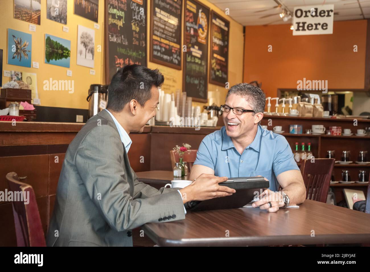 Salesman talking to owner in cafe Banque D'Images