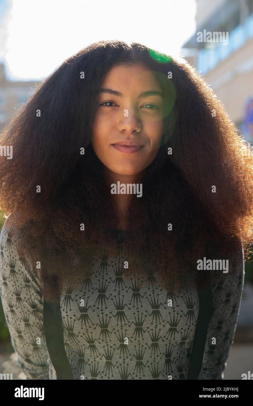 Portrait d'une femme avec de longs cheveux debout à l'extérieur, regardant l'appareil photo Banque D'Images