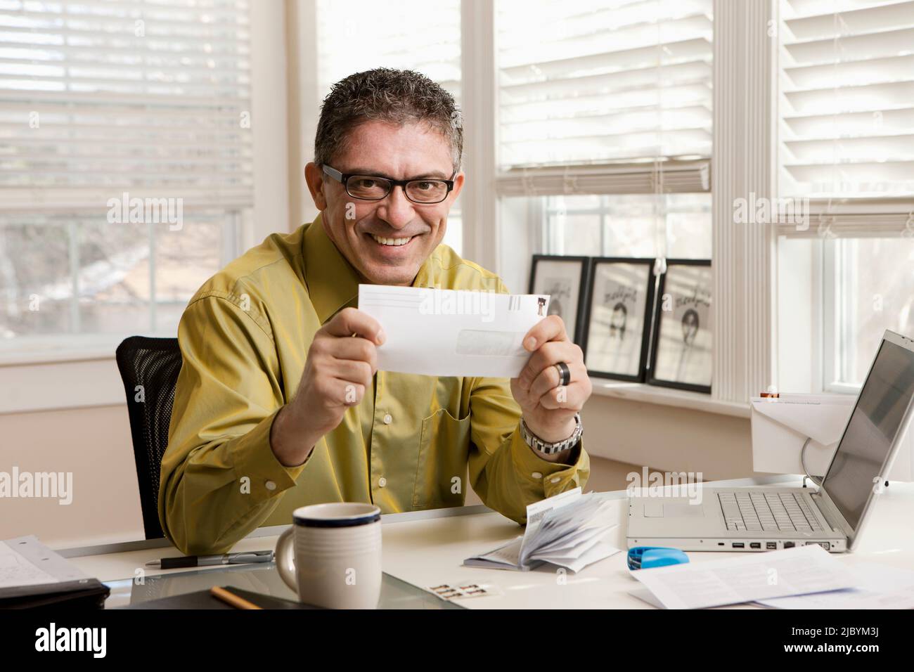 Hispanic man holding envelope Banque D'Images