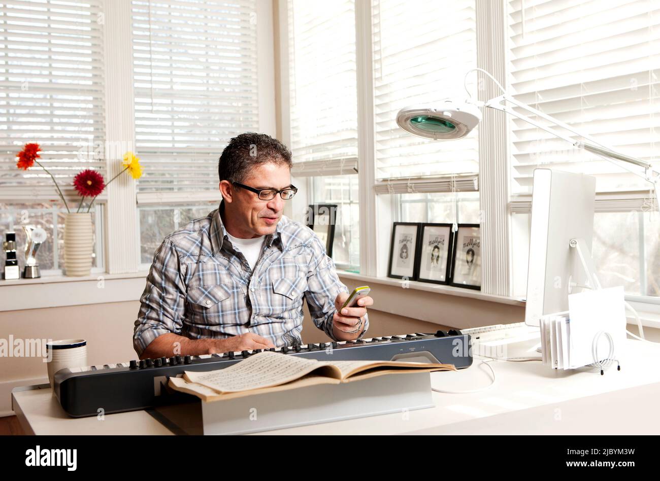 Man avec clavier électronique et téléphone cellulaire Banque D'Images