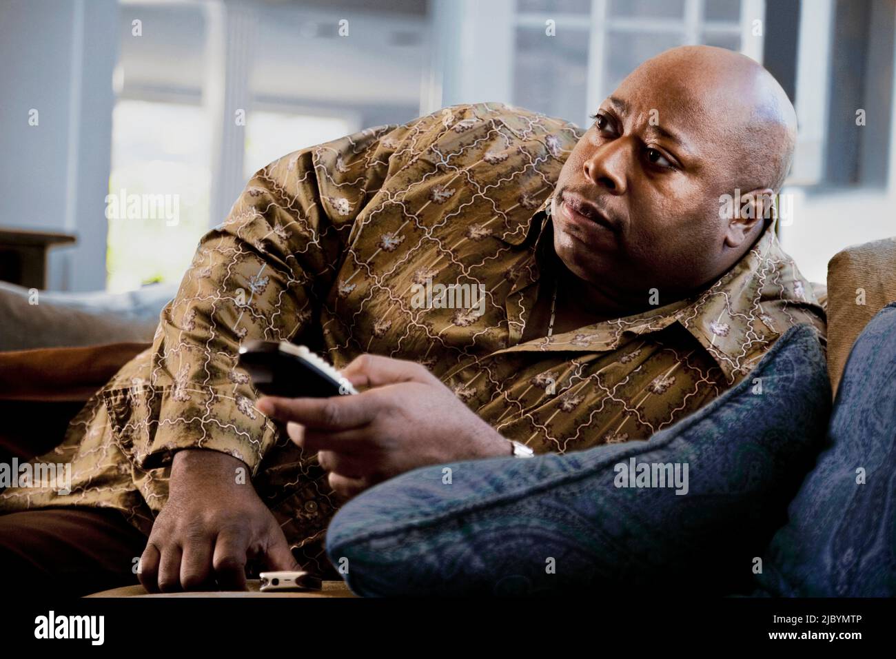 Black man reclining on sofa watching television Banque D'Images