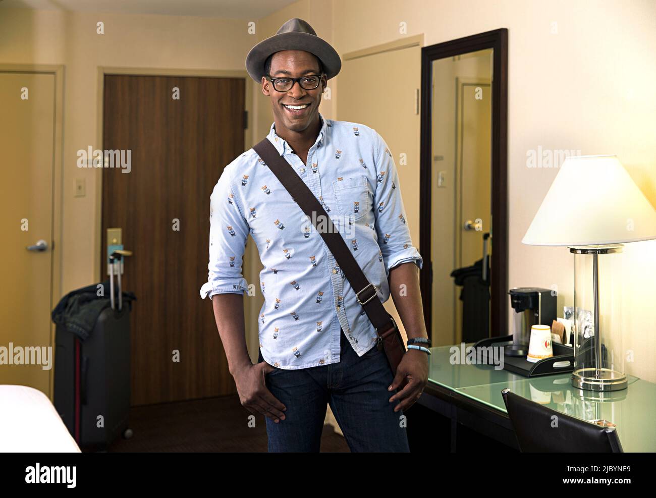 Smiling Black man posing in hotel room Banque D'Images