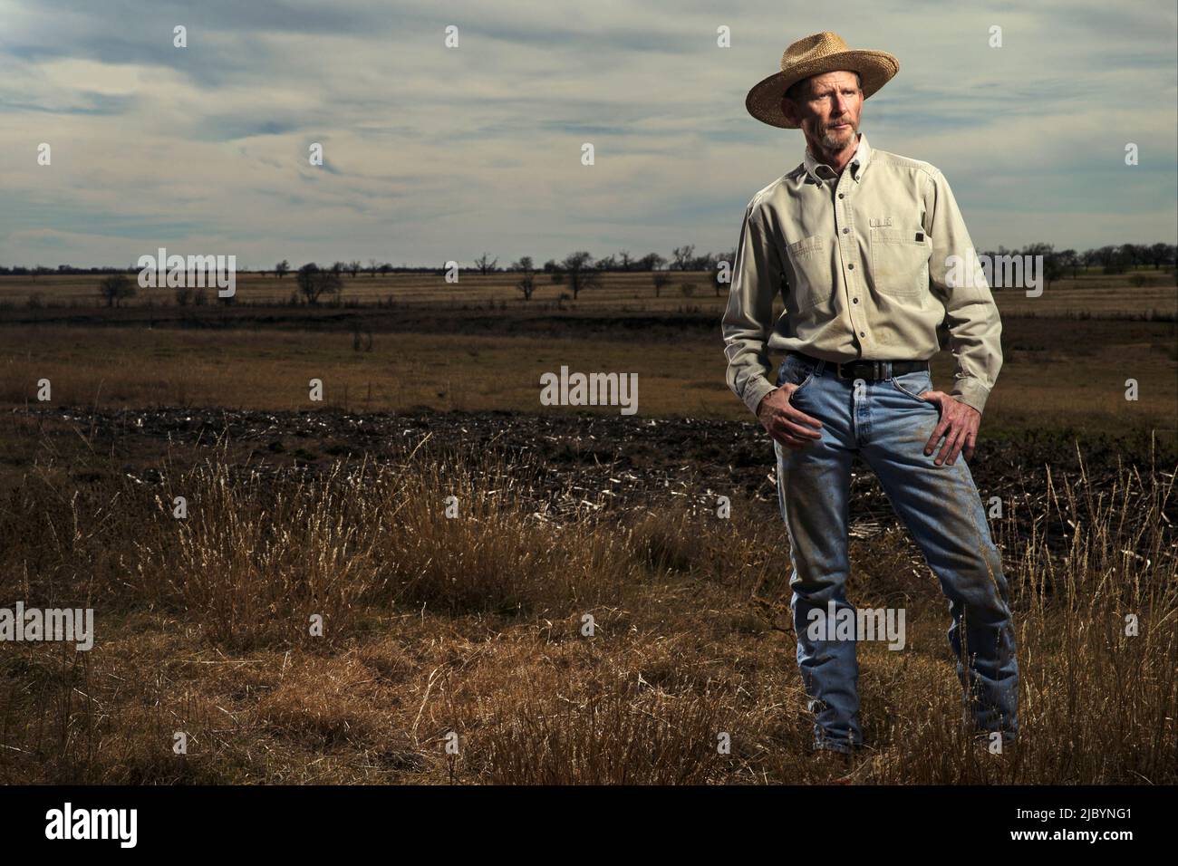 Farmer standing in field Banque D'Images