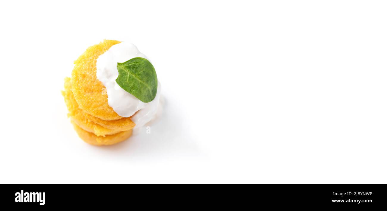 Pancakes frit polenta sur un fond blanc isolé. Crêpes empilées l'une sur les autres crêpes avec du fromage et des épinards. Vue de dessus. Vide Banque D'Images