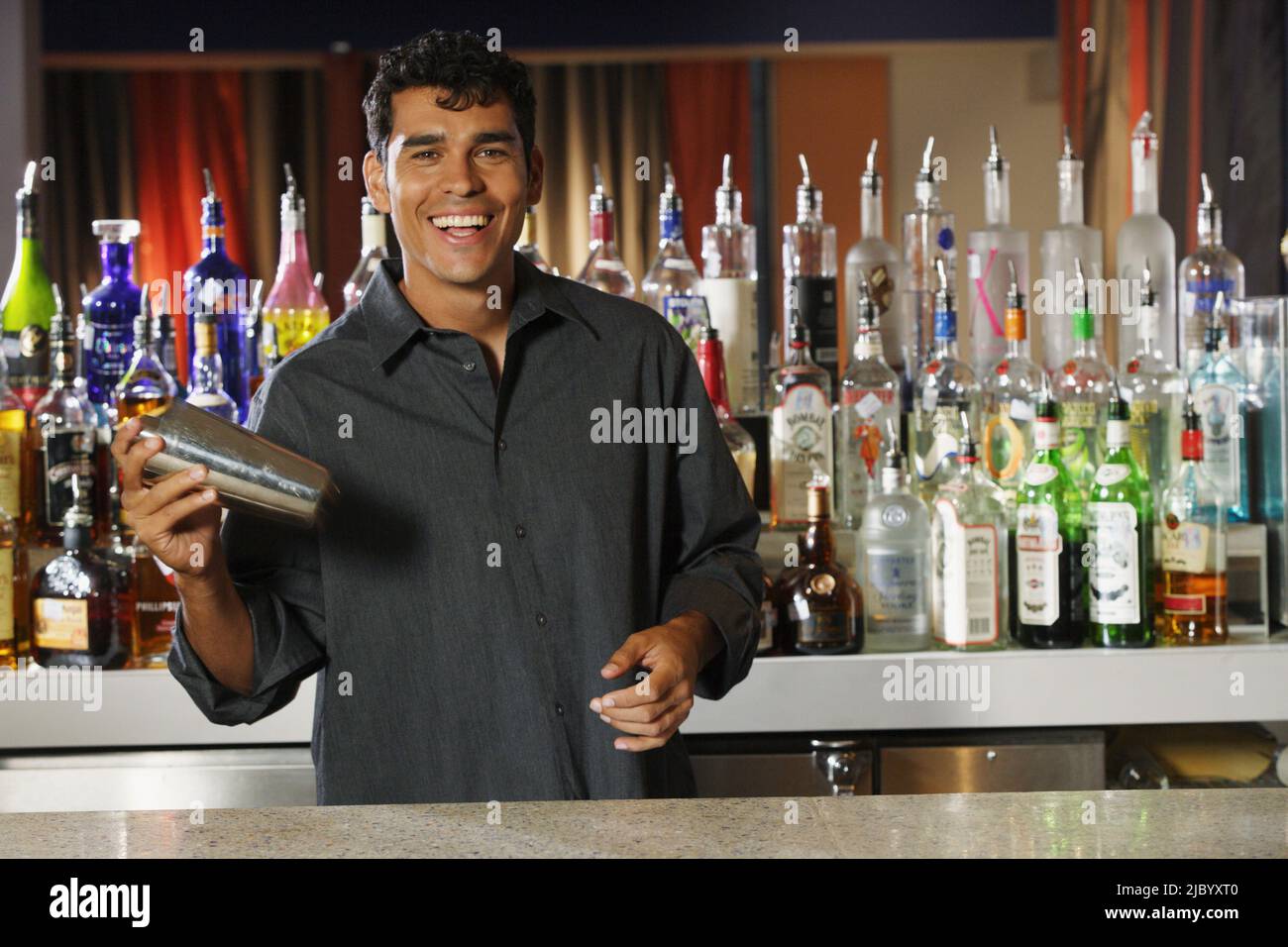 Hispanic male bartender making verre Banque D'Images