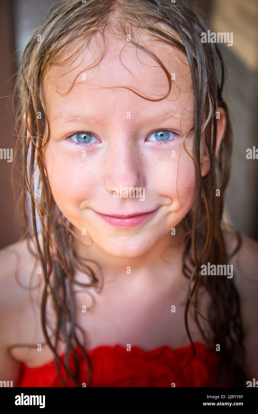 Joyeux drôle petite fille blone avec les cheveux mouillés après la pluie dans un jour d'été ou de printemps Banque D'Images