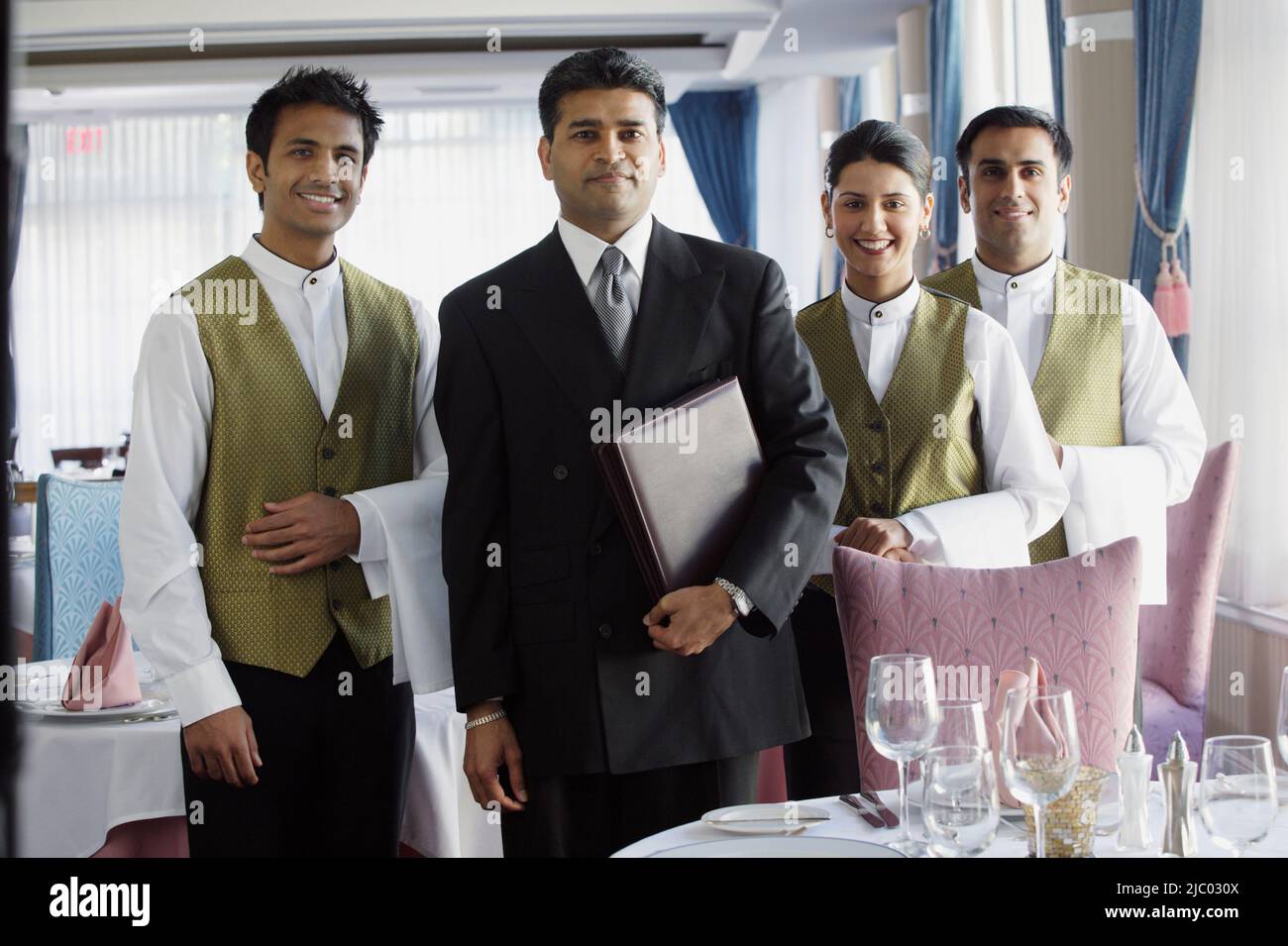 Serveurs smiling for the camera in restaurant Banque D'Images