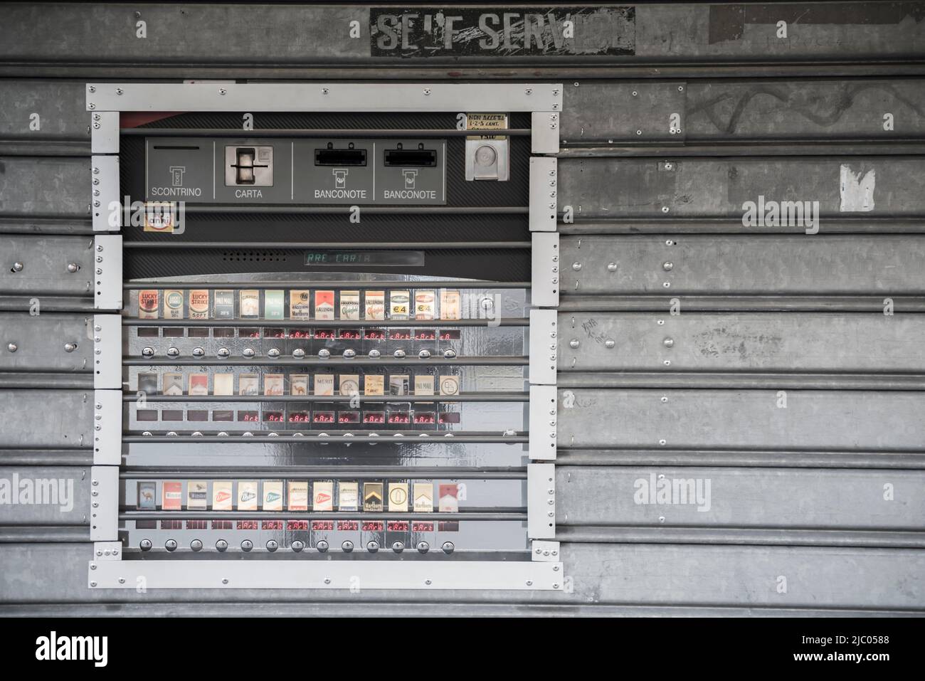 Machine à cigarettes sur un mur métallique en plein air à Gênes, Ligurie en Italie. Banque D'Images