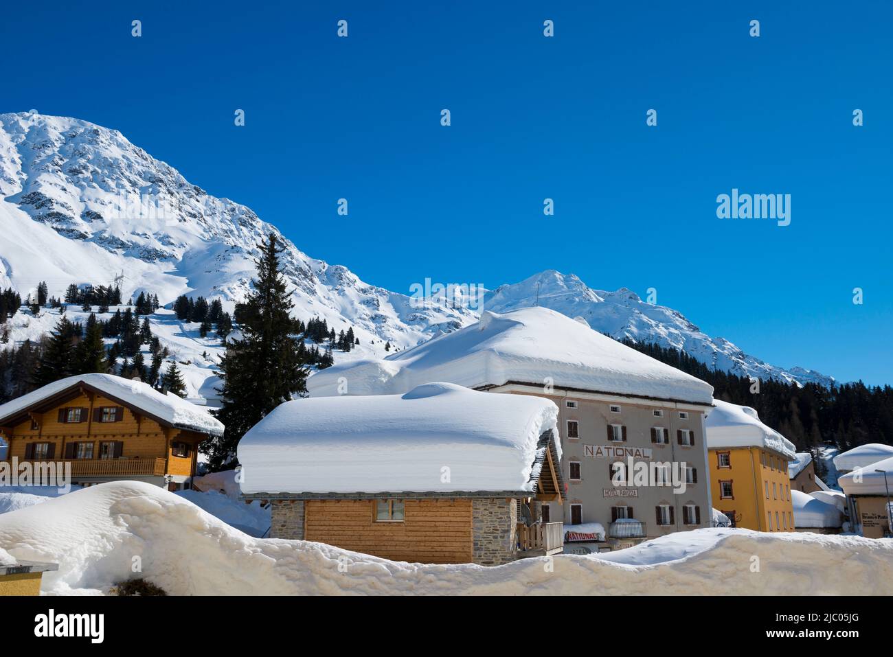 Maison en paysage d'hiver avec pic de montagne en une journée ensoleillée à San Bernardino, Grisons en Suisse. Banque D'Images