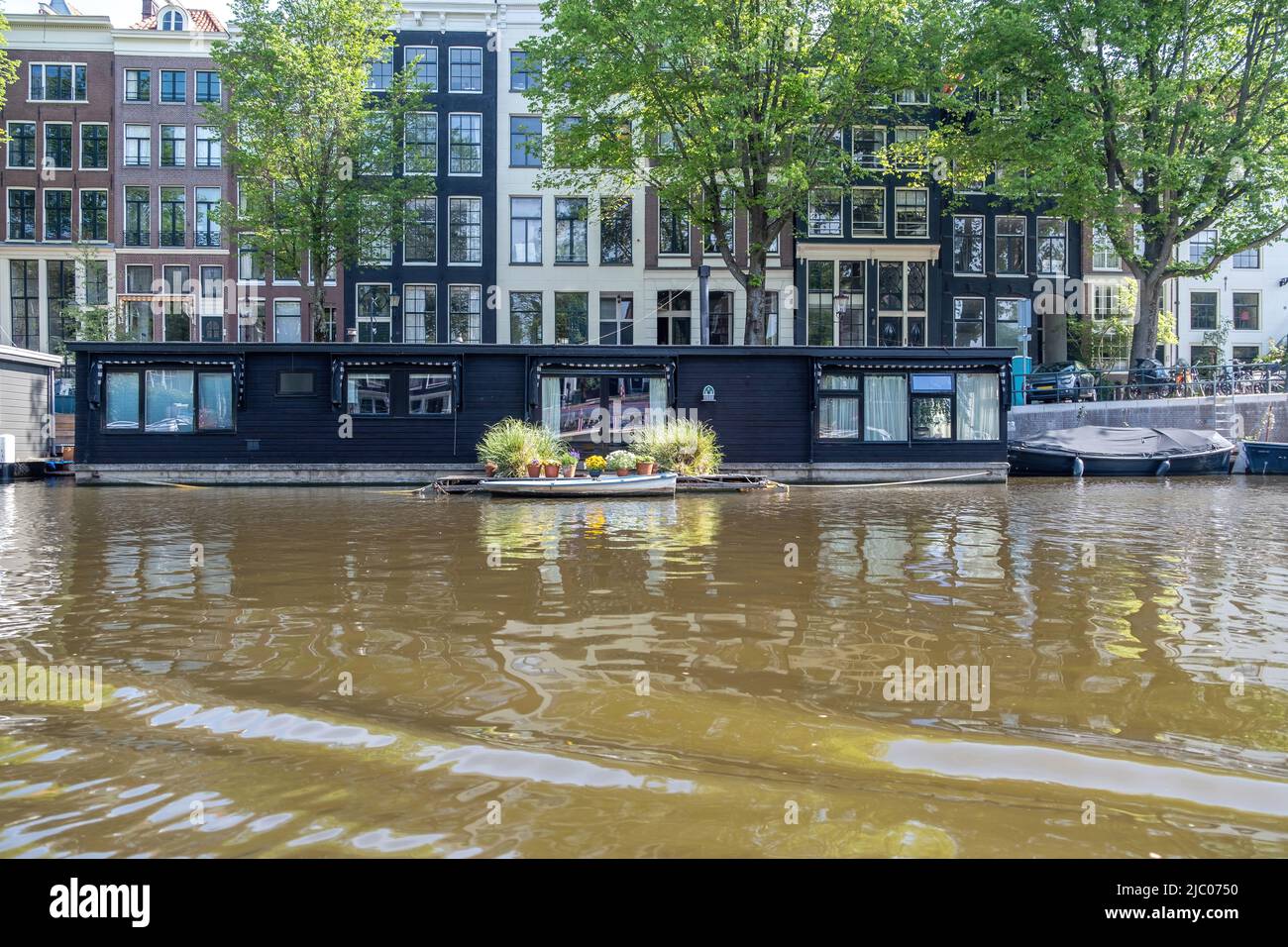 Canal d'Amsterdam, pays-Bas. Bateaux et bateaux-moteur flottants sur l'eau. Maisons traditionnelles façade en brique, vélos garés sur un pont au-dessus du canal Banque D'Images