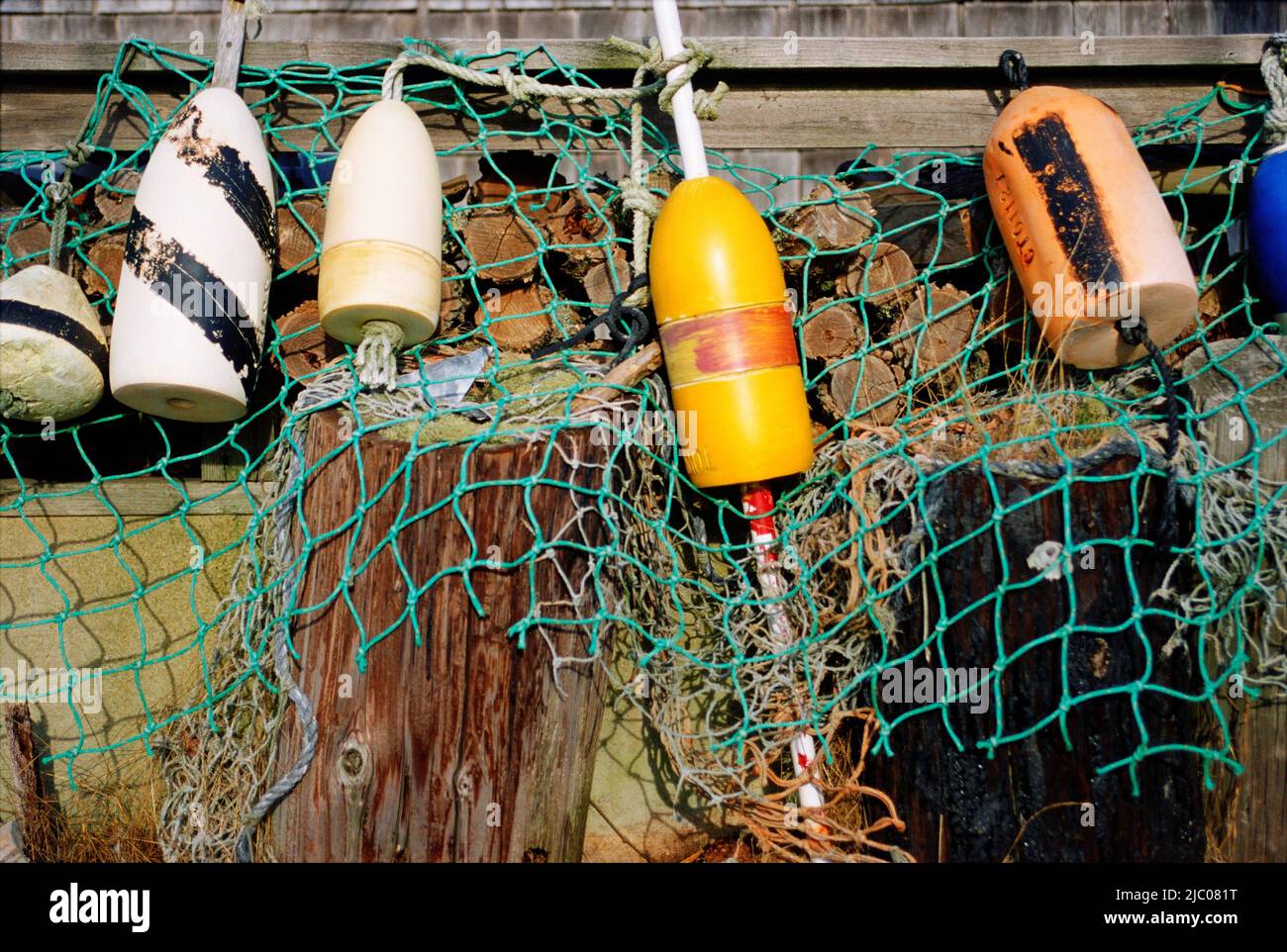 Des bouées et un filet de pêche accroché au bord d'un quai à Port Menemsha, Martha's Vineyard, comté de Dukes, Massachusetts, USA Banque D'Images