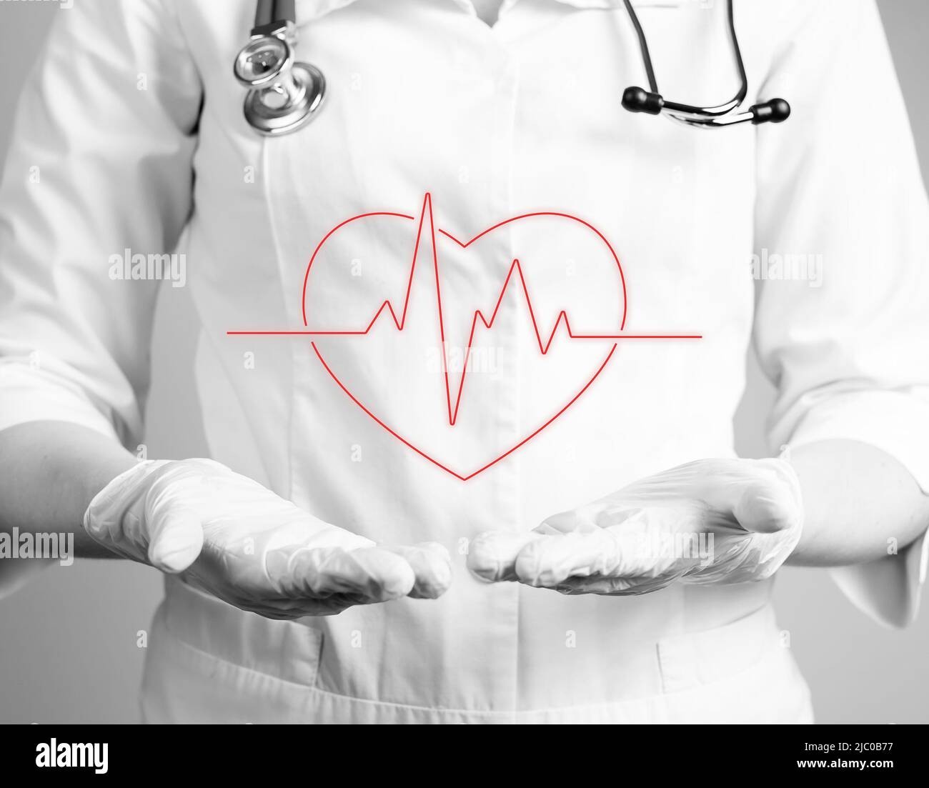 Cœur avec rythme cardiaque sur les mains du médecin en gants. Réalisation d'un test d'électrocardiogramme, vérification du concept des problèmes cardiaques. Travail du cardiologue. Noir et blanc. Photo de haute qualité Banque D'Images