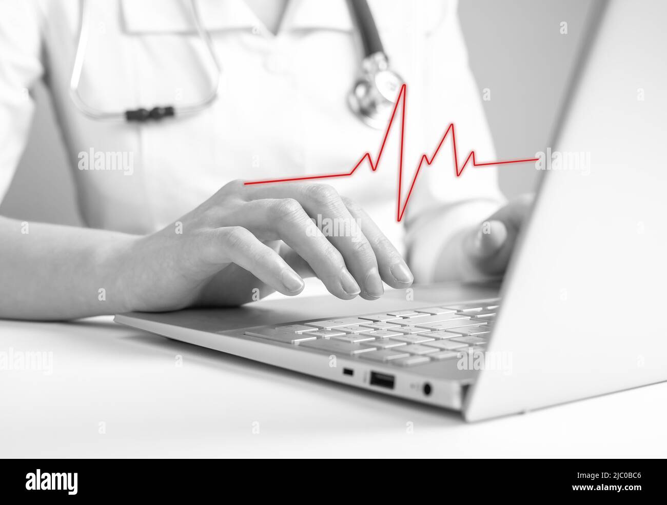 Médecin utilisant un ordinateur portable pour lire les résultats d'électrocardiogramme, en vérifiant les signes de maladies cardiaques. Problèmes cardiovasculaires, anomalie concept de détection. Noir et blanc. Photo de haute qualité Banque D'Images