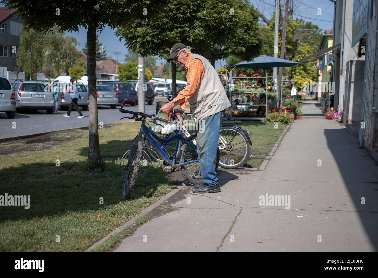 Temerin, Serbie, 1 juin 2022 : un citoyen âgé chargeait un vélo avec des sacs à provisions Banque D'Images