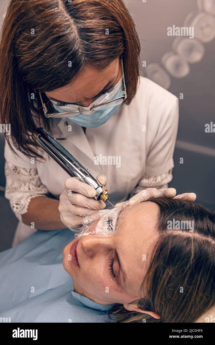 Cosméticien utiliser le plasma fibroblaste peau serrer traitement cosmétique, vue de dessus Banque D'Images