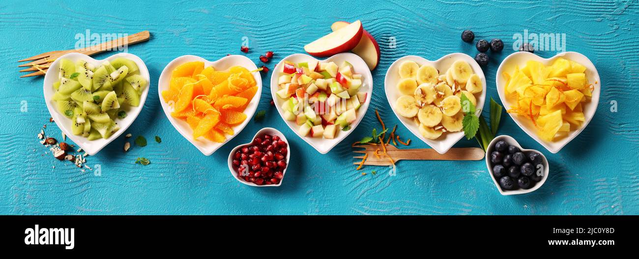 Plaques de fruits en forme de cœur sur fond bleu ou cyan Banque D'Images