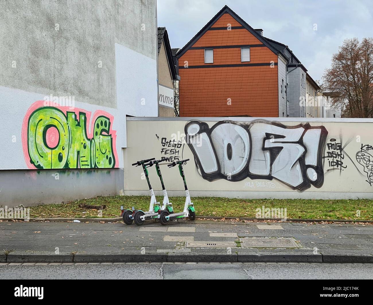 Garés e-trottinettes et graffiti sur le mur de la maison, Allemagne Banque D'Images
