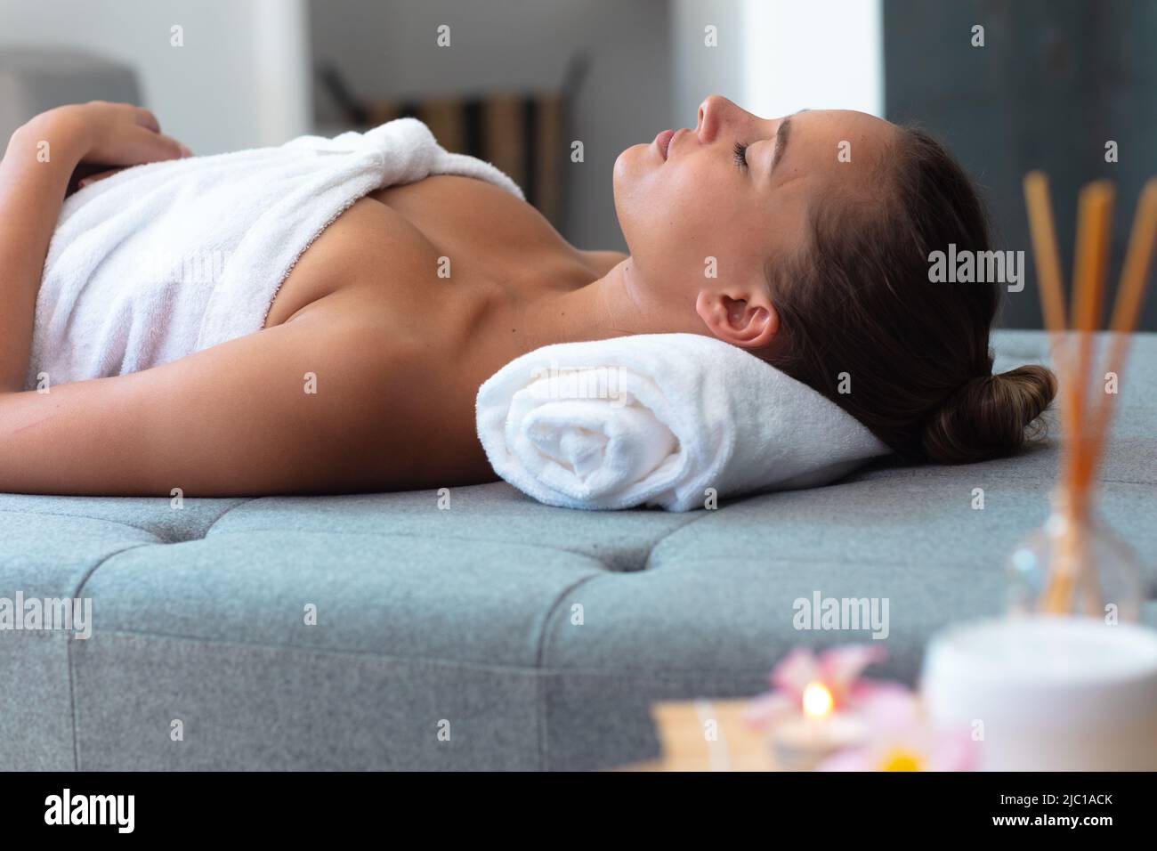 Jeune femme caucasienne dans un peignoir de détente sur la table de massage Banque D'Images