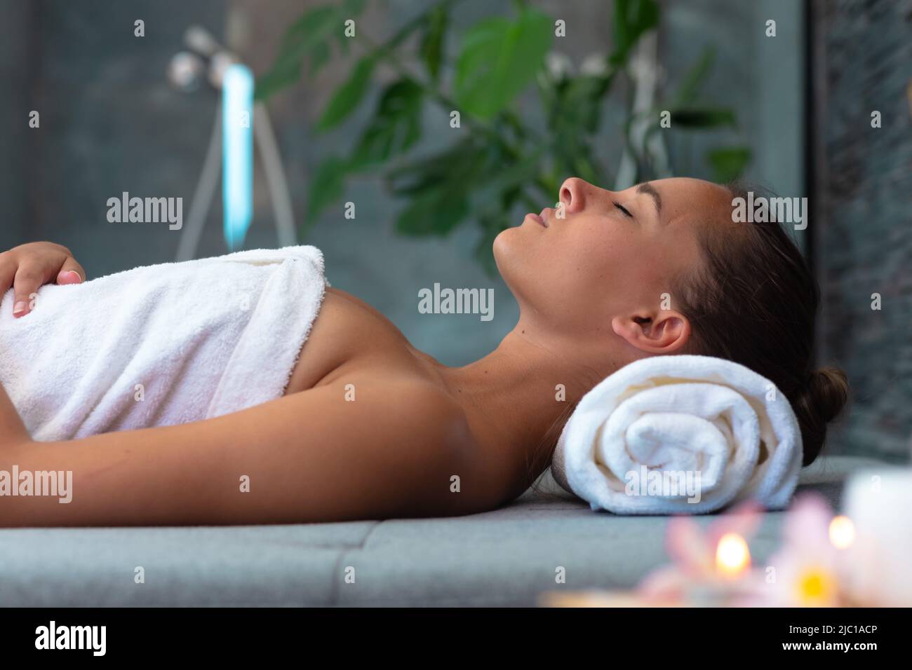 Jeune femme caucasienne dans un peignoir de détente sur la table de massage Banque D'Images