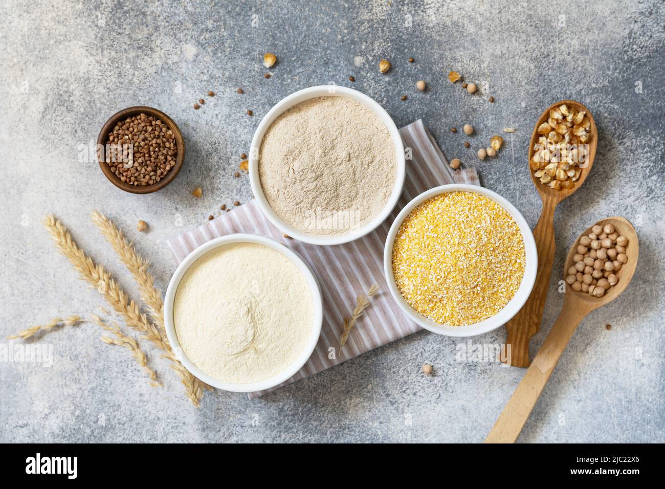 Aliments et ingrédients sans gluten. Céréales et farines grossières, farine de maïs, farine de sarrasin, farine de pois chiches sur fond de pierre grise. Vue de Banque D'Images