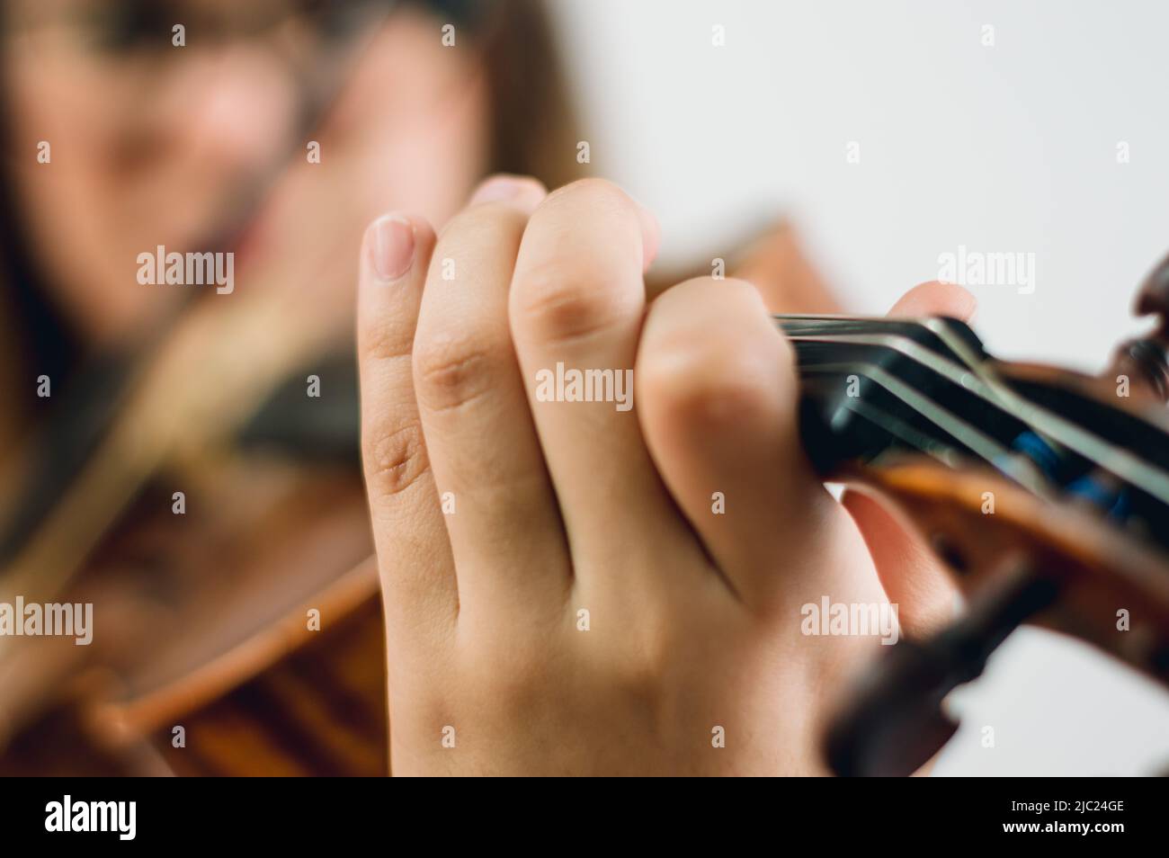 gros plan main femelle sur platine à violon faire une note, avec femme dans un arrière-plan flou avec espace de copie, se concentrer sur main. Banque D'Images