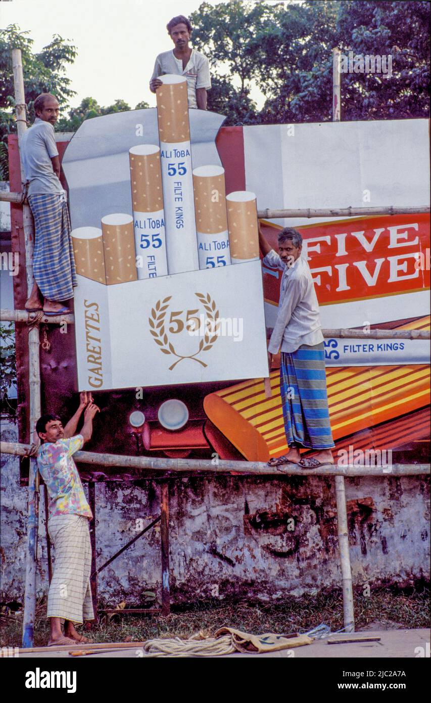 Bangladesh; les hommes placent un panneau d'affichage pour la marque de cigarettes. Banque D'Images