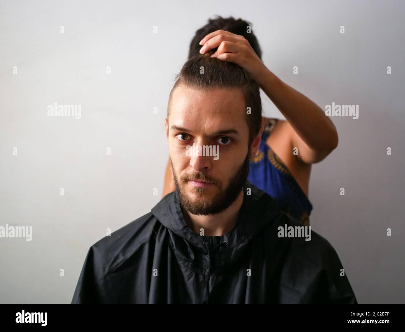 Jeune homme blanc avec barbe Obtenez une coupe de cheveux par une jeune femme Banque D'Images