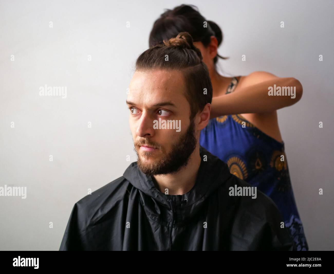 Jeune homme blanc avec barbe Obtenez une coupe de cheveux par une jeune femme Banque D'Images