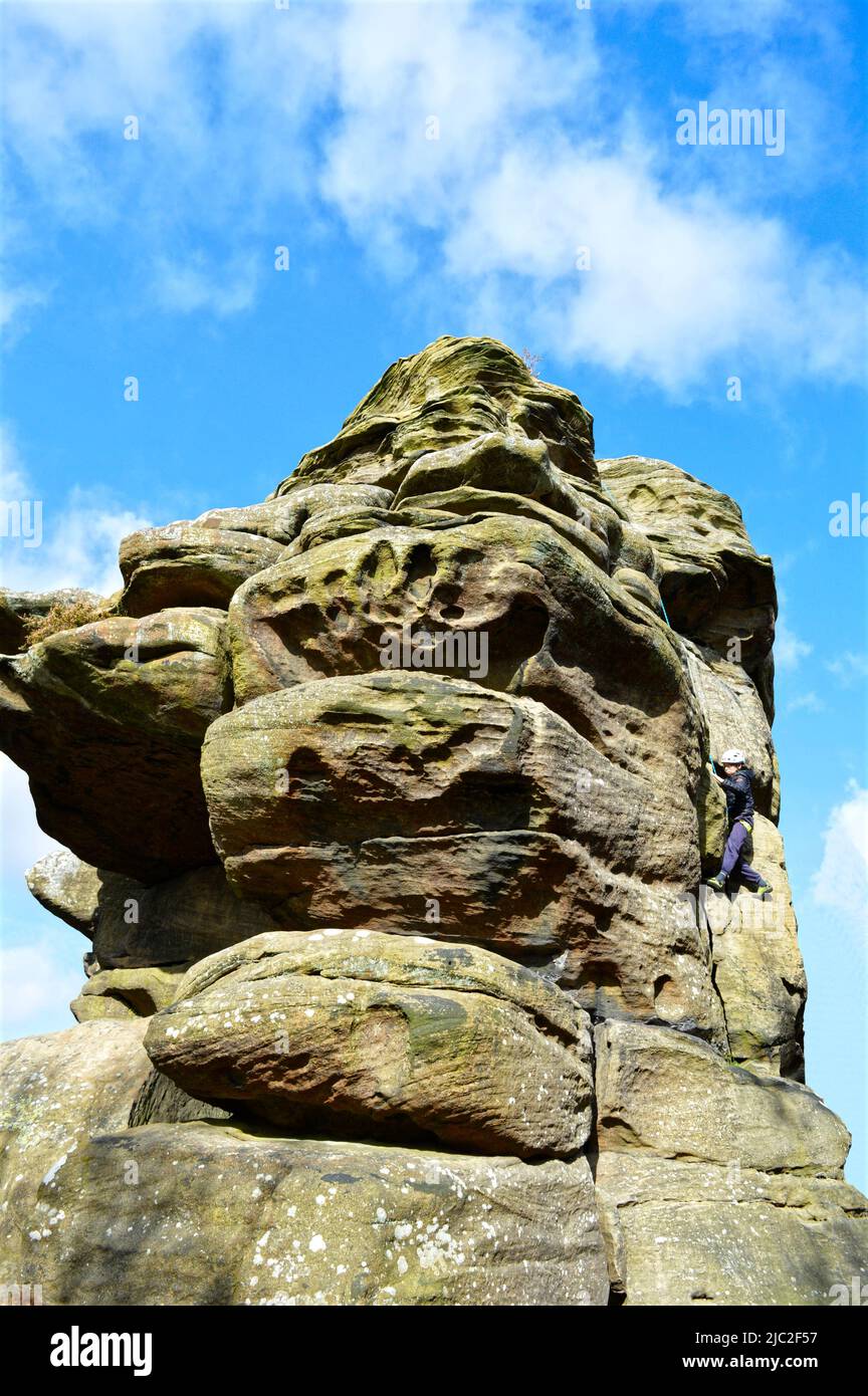 Enfant apprenant à grimper sur les rochers de Bingham dans le Yorkshire du Nord de Harrogate Banque D'Images