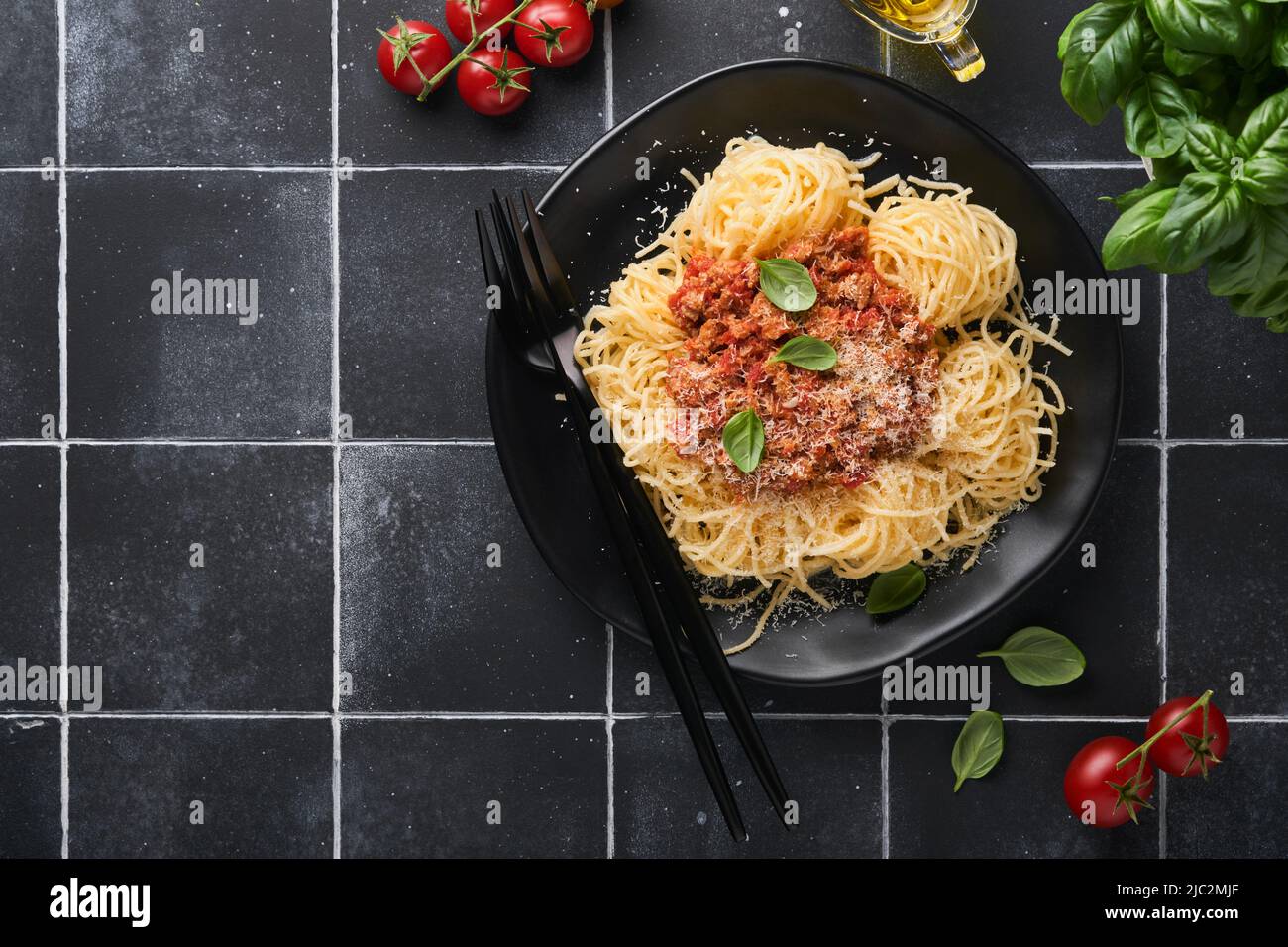 Pâtes tagliatelles aux boulettes de viande sauce tomate, basilic et parmesan sur fond de pierre noire ou de béton.Cuisine italienne traditionnelle et cuisin Banque D'Images