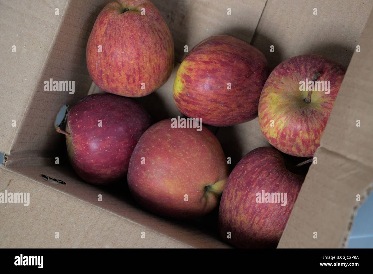 Pommes rouges dans une boîte en carton sur le marché agricole Banque D'Images